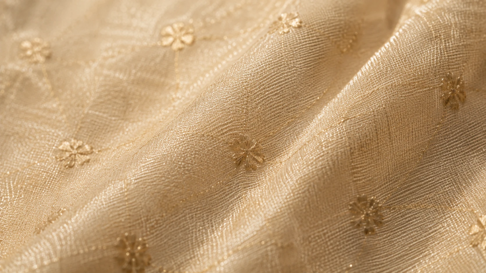 Close-up of gold chanderi fabric showing woven floral booti motifs and its natural sheen